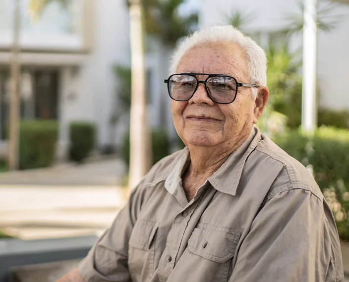 happy older man sitting on bench outside