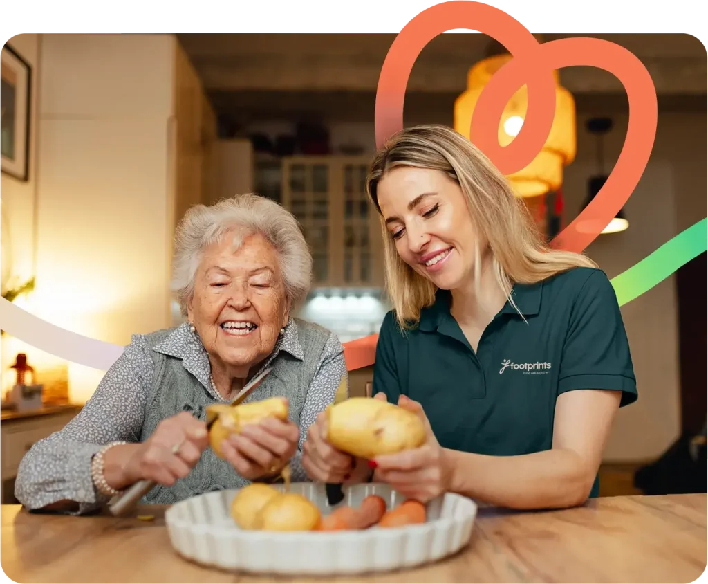 Lady helping older woman peel potatoes